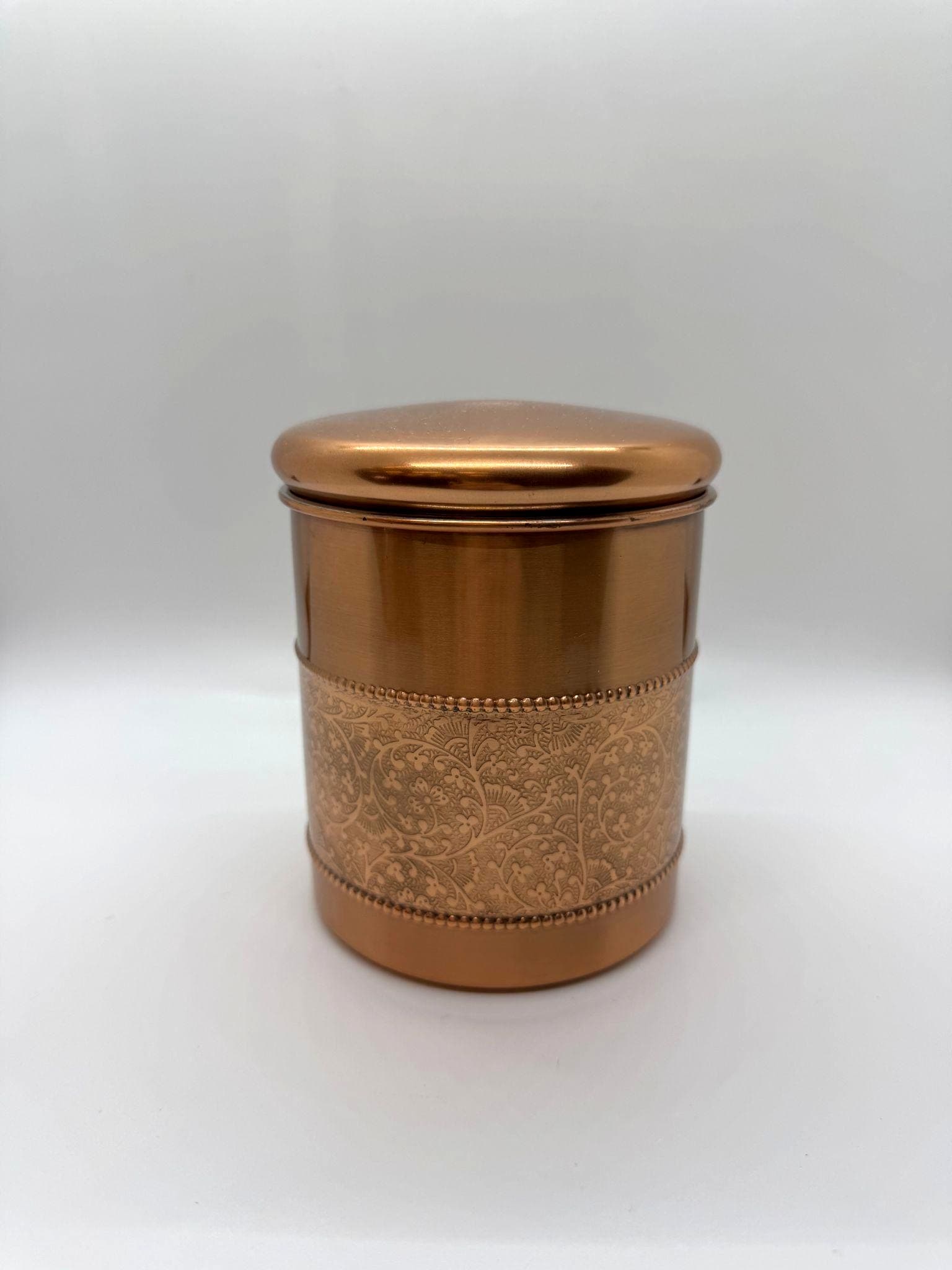 Copper canister urn with warm metallic finish.
