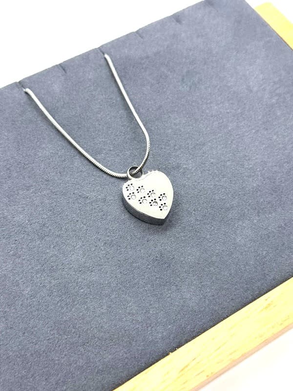 Silver necklace with crystal-accented paw design.
