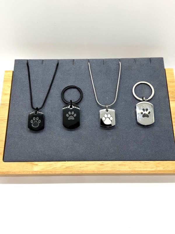 Dog tag style piece, wearable as keychain or necklace. Available in black and silver.