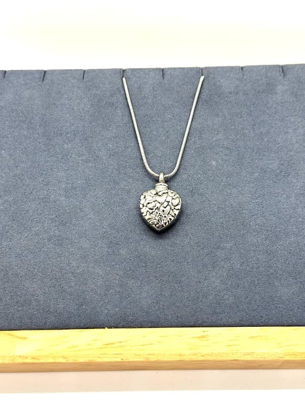 Silver heart pendant filled with smaller heart designs.