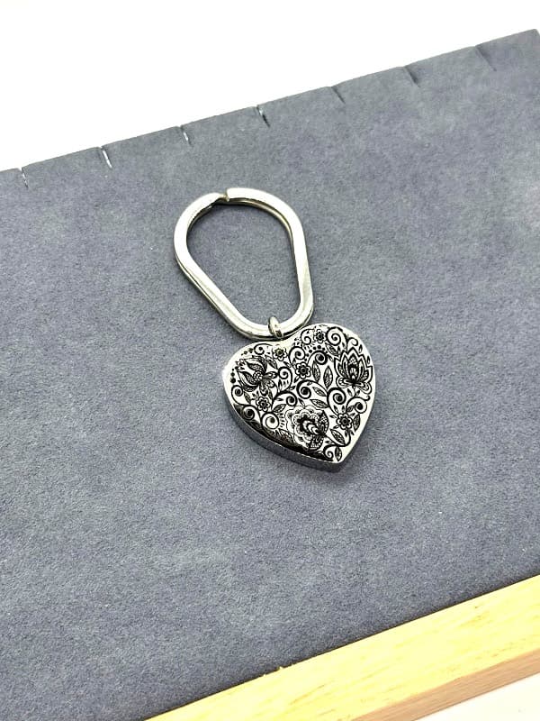 Silver heart keychain with paisley etching on both sides.