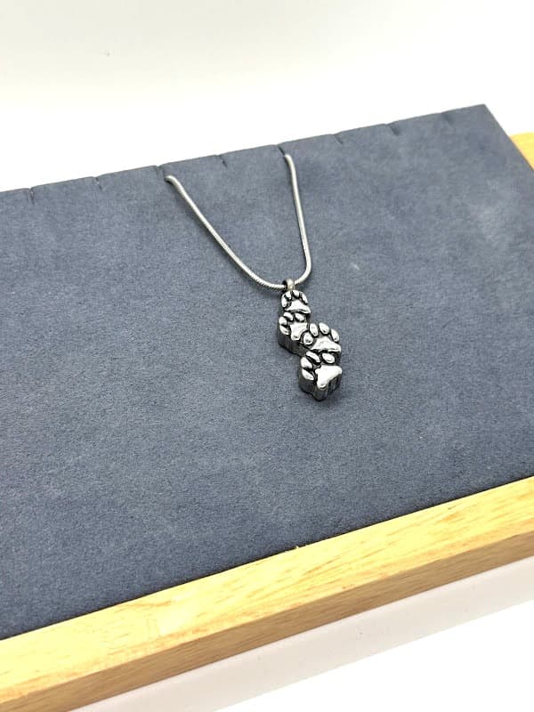 Silver necklace with paw step design.