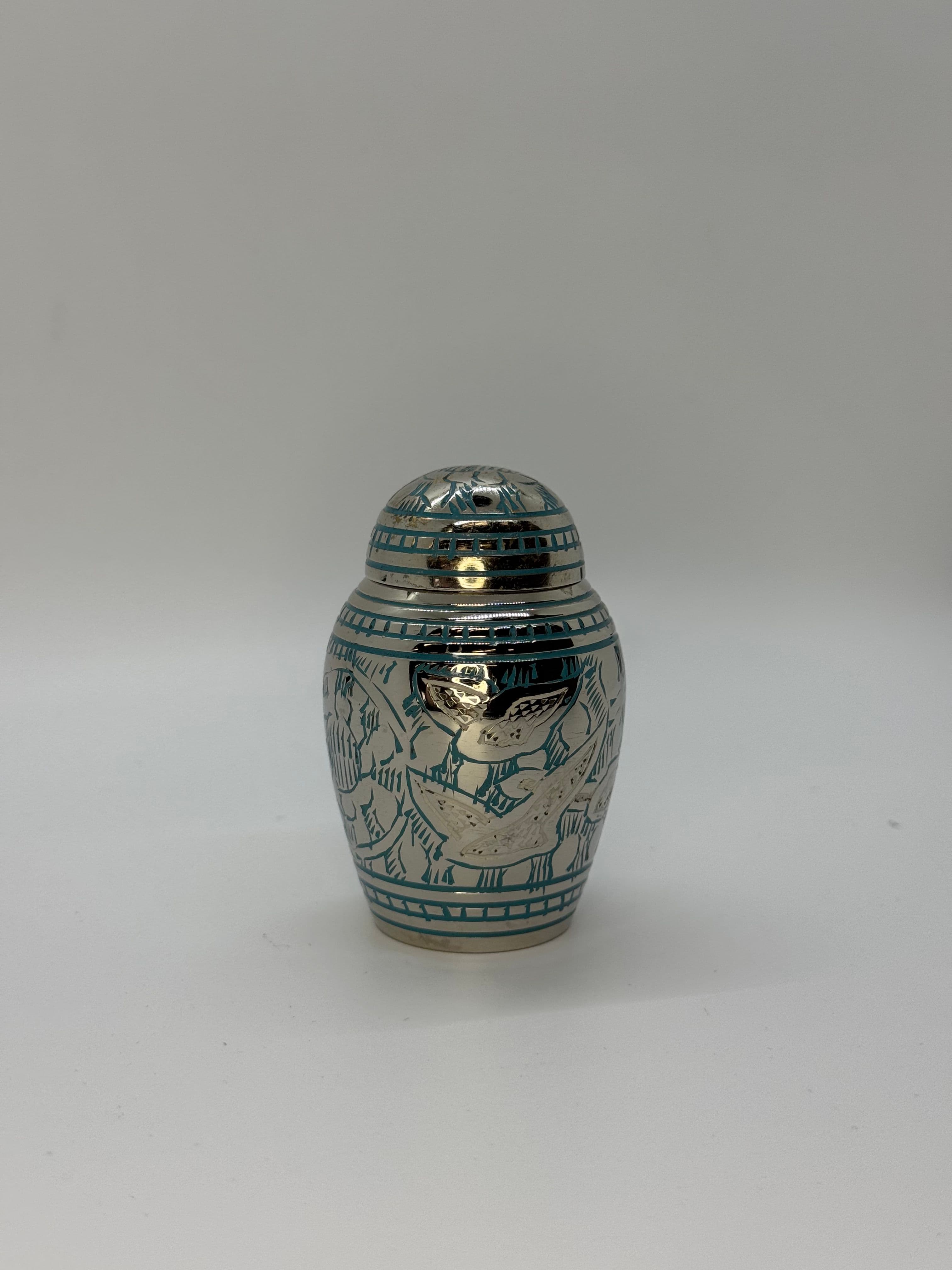 Silver color keepsake urn with blue engraving, featuring a domed top.