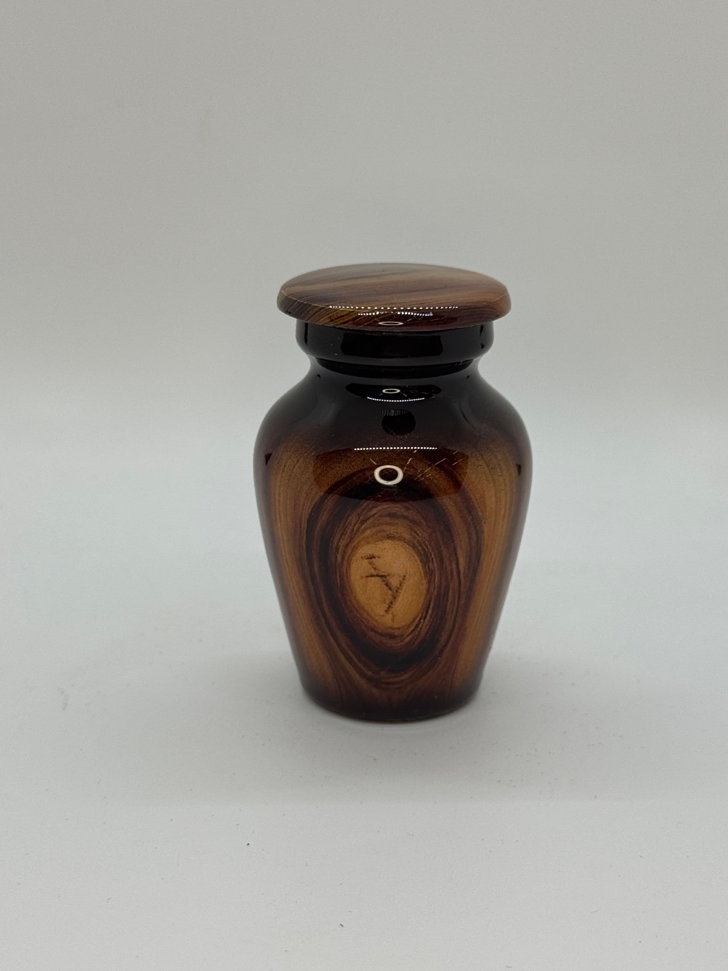 Small metal keepsake urn with wood grain detailing.
