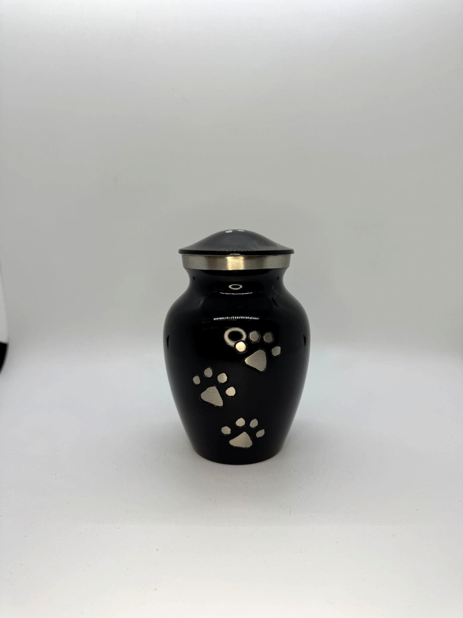 Black urn with silver paw print accents from the Paws to Heaven collection.