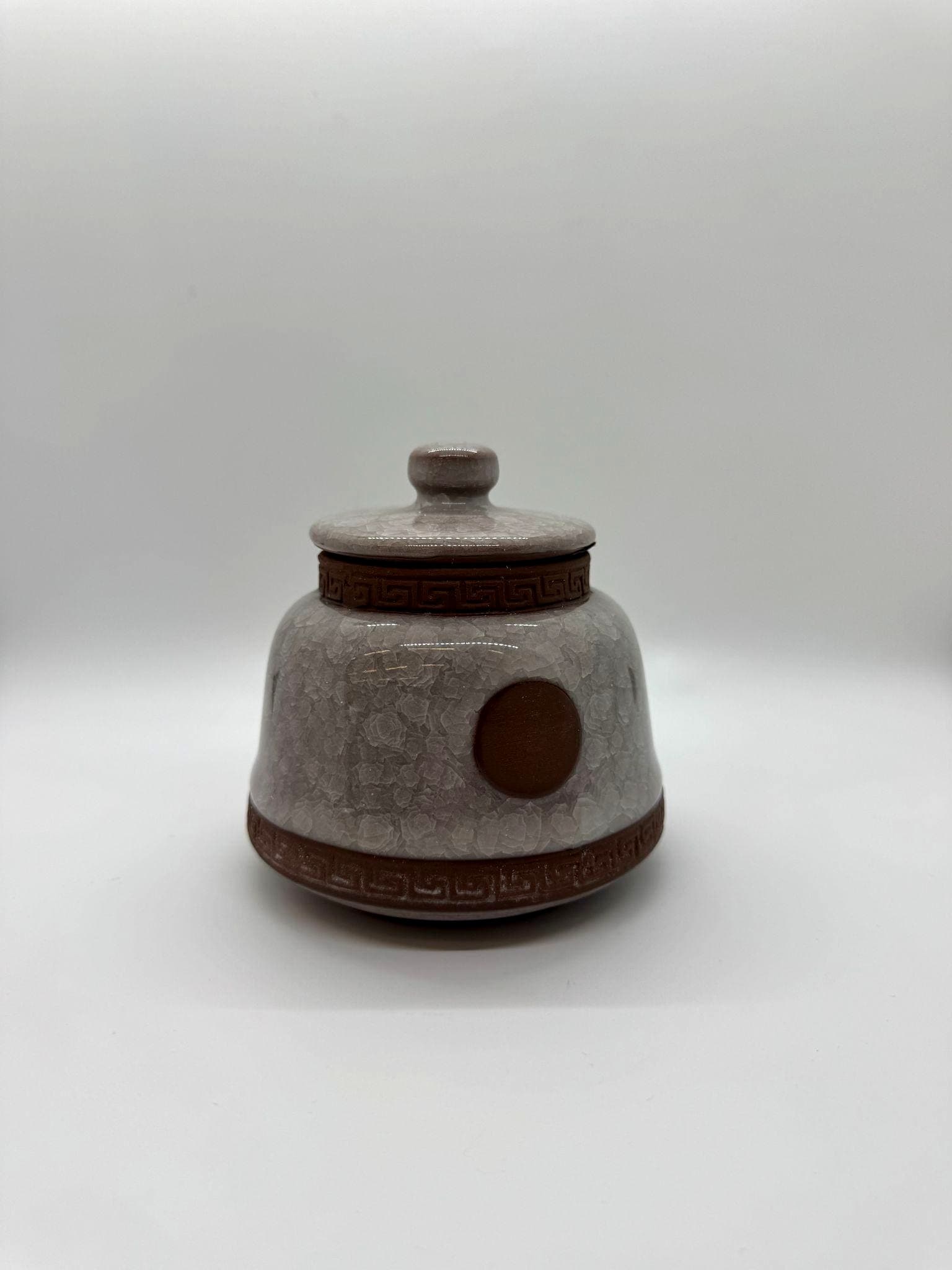 Handcrafted taupe ceramic urn with earthy tones.