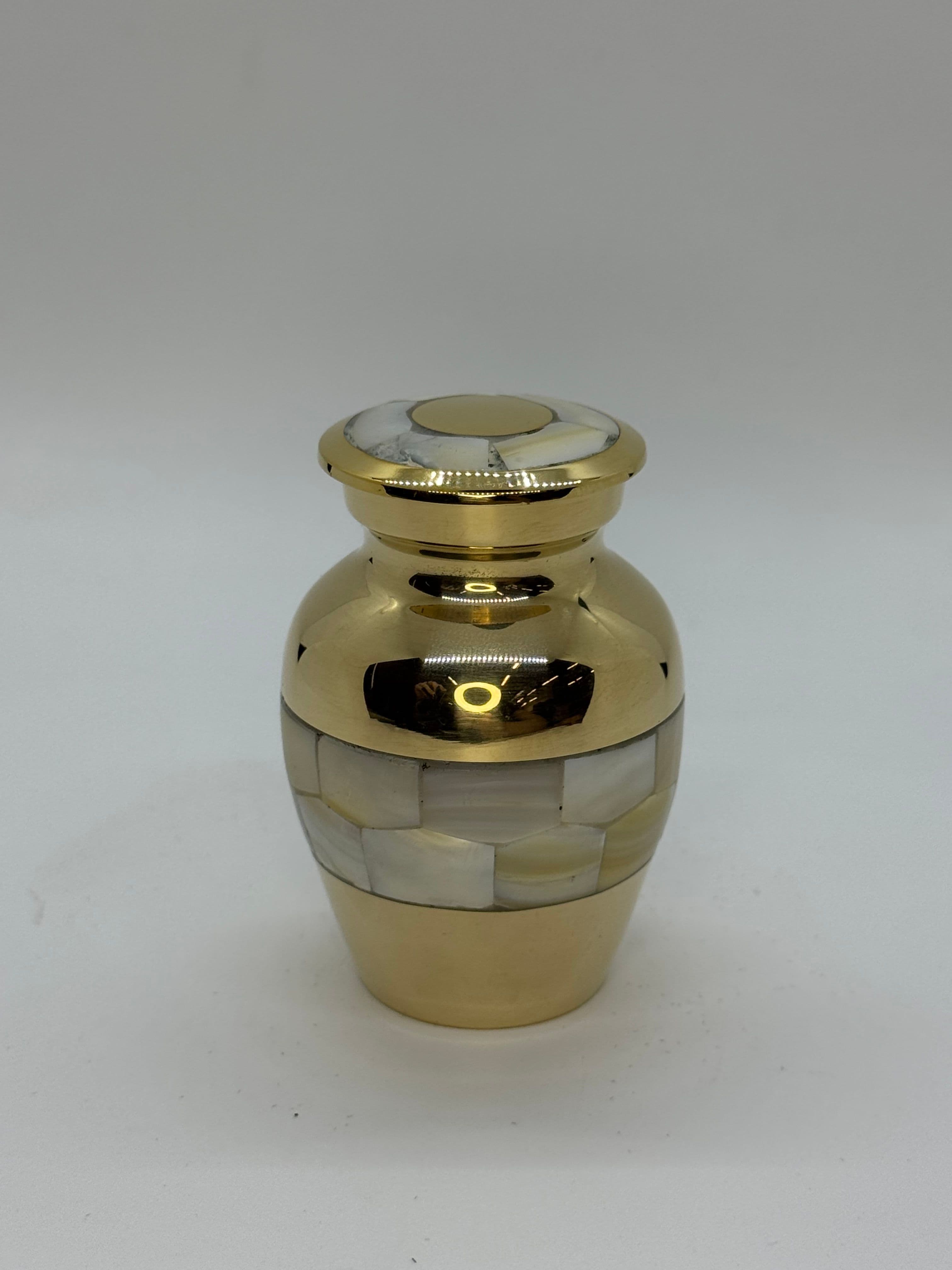 Gold color keepsake size urn with Mother of Pearl embellishments.