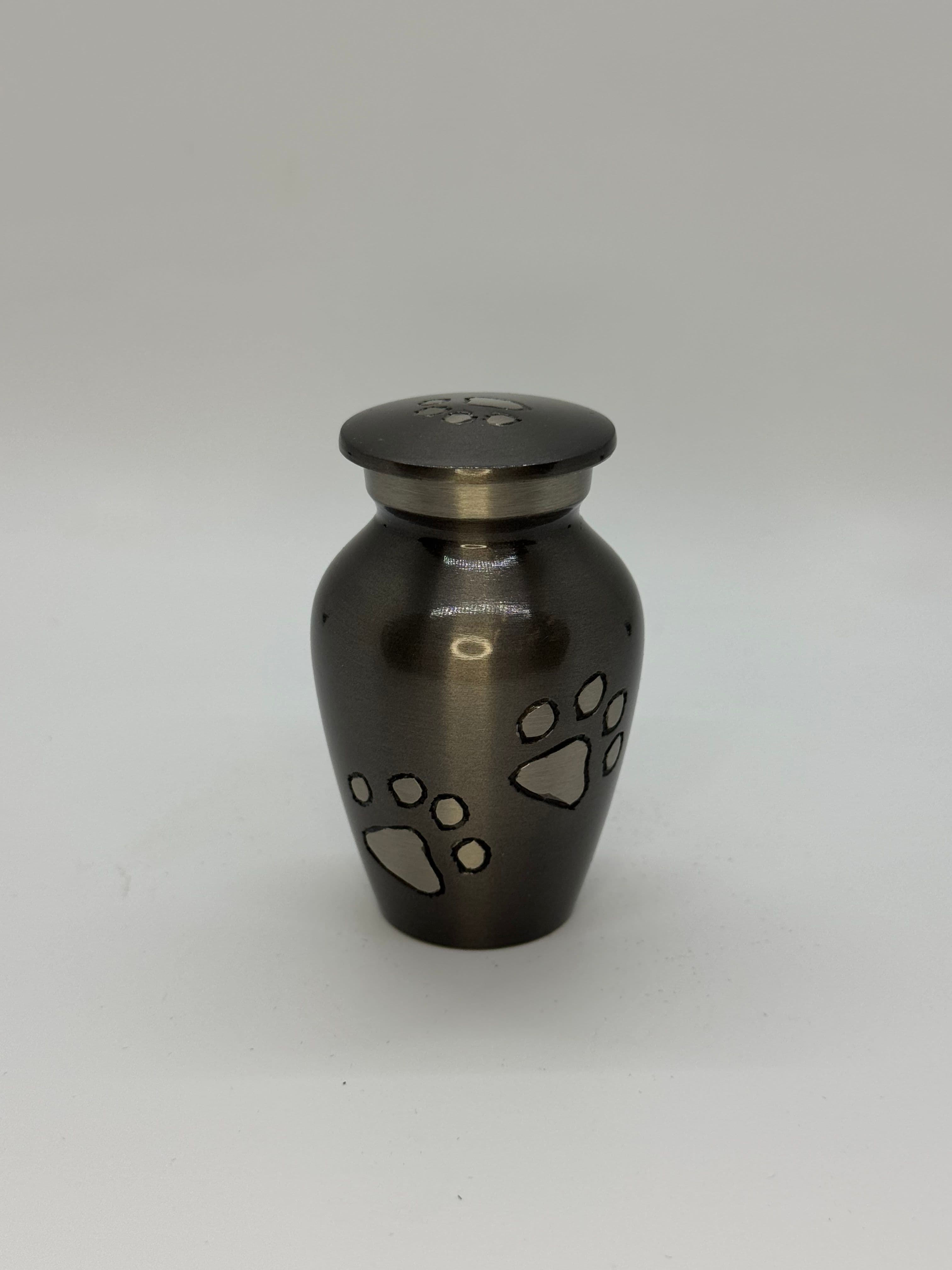 Metal keepsake urn with paw embelishments.