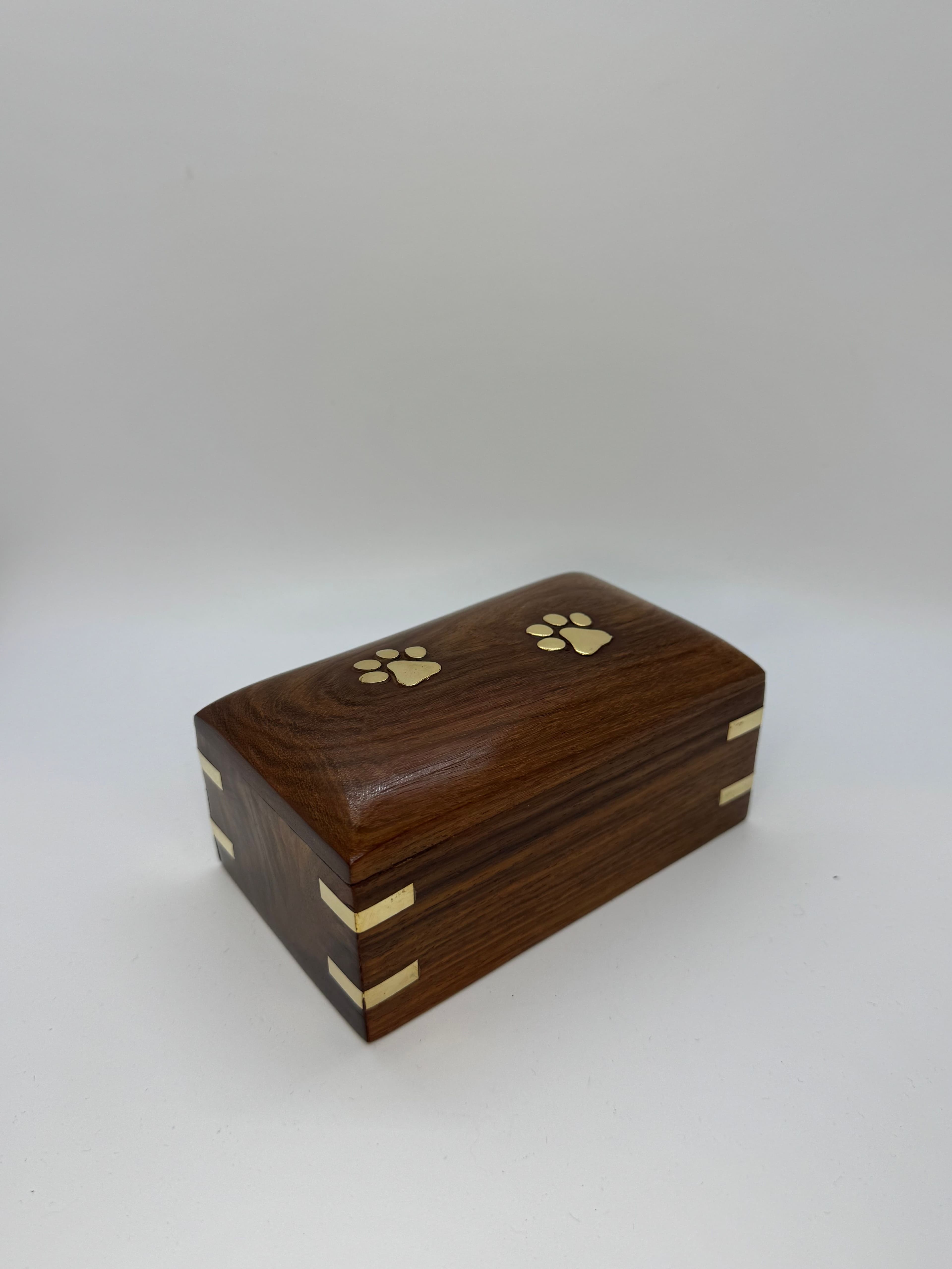 Brass-corner wooden urn with brass paw print accents.